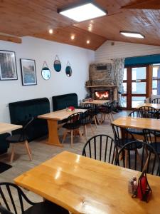 a restaurant with tables and chairs and a fireplace at Agroturystyka U BOŻENY in Przysłup