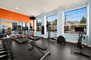 un gimnasio con cintas de correr, equipos de ejercicio y ventanas en Hilton Garden Inn Williamsburg, en Williamsburg