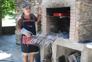 un hombre en un delantal parado junto a un horno de ladrillo en Cortijos Rey Fini, en Granada