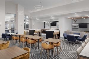 a cafeteria with tables and chairs and a kitchen at Homewood Suites by Hilton York in York