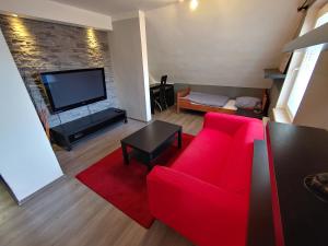 sala de estar con sofá rojo y TV de pantalla plana en Privat Apartment Zdenko, en Ostrava