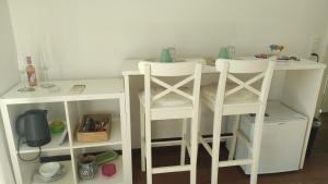 a white table and two stools in a room at Bell orizzonte in Locarno