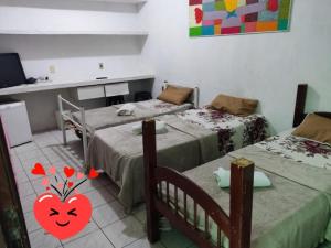Habitación con 2 camas, mesa y barra. en POUSADA BRASIL RECIFE, en Recife