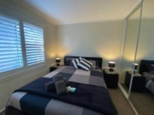 a bedroom with a blue and white bed and a window at Self contained 2 bedroom unit in Williamstown