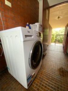 a washing machine in a room with a brick wall at Self contained 2 bedroom unit in Williamstown