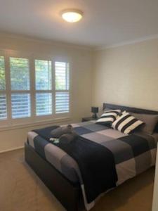 a bedroom with a large bed with striped pillows at Self contained 2 bedroom unit in Williamstown