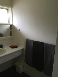 a bathroom with a sink and a mirror and towels at Self contained 2 bedroom unit in Williamstown
