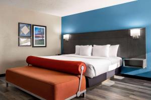 a hotel room with a bed and a bench at La Quinta by Wyndham Chicago Tinley Park in Tinley Park