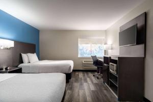 a hotel room with two beds and a television at La Quinta by Wyndham Chicago Tinley Park in Tinley Park