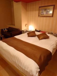 a bedroom with a large bed and a couch at Hotel Fantacy (Adult Only) in Hamamatsu