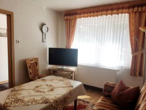 a living room with a table and a television at Ferienwohnung Haus Waldesrand in Norderney