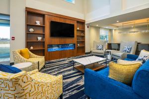 a living room with two blue couches and a tv at Comfort Inn & Suites in Ingersoll