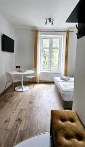 a room with a bed and a desk and a table at Pawia Apartments Centrum in Krakow