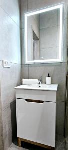 a bathroom with a white sink and a mirror at Pawia Apartments Centrum in Krakow