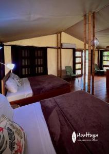 a bedroom with two beds and a tent at Houttuyn Wellness River Resort in Paramaribo