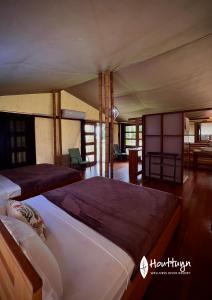 a bedroom with two beds and a living room at Houttuyn Wellness River Resort in Paramaribo