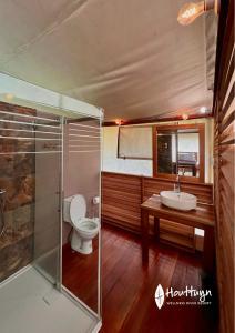 a bathroom with a toilet and a sink at Houttuyn Wellness River Resort in Paramaribo