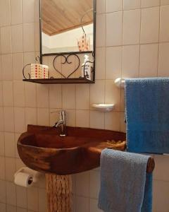 y baño con lavabo de madera y espejo. en La Posada de Cloe en Seclantás