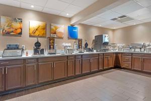 a large kitchen with wooden cabinets and appliances at Comfort Inn & Suites in Johnstown