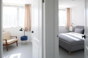 1 dormitorio con 1 cama, 1 silla y ventanas en Modern Apartment on London's Southbank en Londres