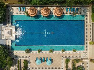 an overhead view of a swimming pool with two chairs and a pool at Taj Krishna in Hyderabad