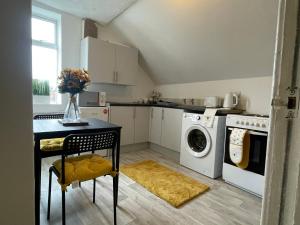 a kitchen with a table and a washing machine at Inviting 1-Bed Apartment in Leeds in Leeds