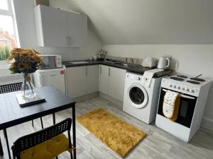 a kitchen with a stove and a washing machine at Inviting 1-Bed Apartment in Leeds in Leeds
