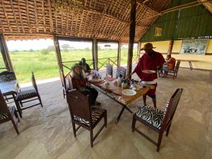 a man and a woman sitting at a table at Amboseli Discovery Camp in Amboseli