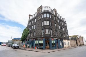 un edificio alto de ladrillo en la esquina de una calle en Pass the Keys Trendy Historic flat sleeps 4 to 6 near Leith Shore, en Edimburgo