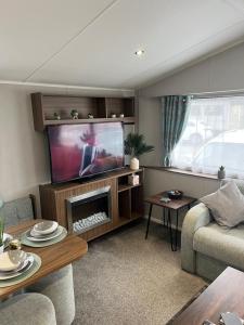 a living room with a flat screen tv and a couch at BlackJak Retreat in Grange Over Sands