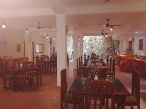 a dining room with tables and chairs in a restaurant at Victory Inn Monaragala in Monaragala