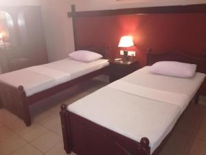 two beds in a room with a red wall at Victory Inn Monaragala in Monaragala