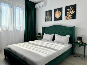 een slaapkamer met een groot bed met een groen hoofdeinde bij KOA - Moon Penthouse in Braşov