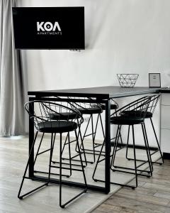 una mesa negra con sillas y un cartel en la pared en KOA - Moon Penthouse, en Brasov