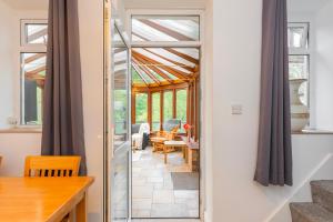 a glass door leading into a room with a dining room at The Trail by Afan Valley Escapes in Cymmer