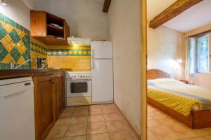 eine Küche mit einem weißen Kühlschrank und einem Bett in der Unterkunft Le Jas charming Mas in Provence with shared pool nature calm space in Flayosc