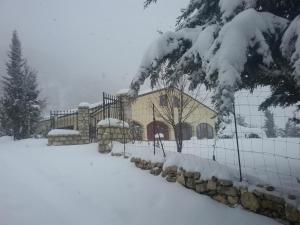 a building covered in snow in front of a fence at Agriturismo Serra Moneta in Santo Stefano Quisquina