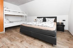 1 Schlafzimmer mit einem großen Bett und 2 Etagenbetten in der Unterkunft Ferienwohnungen Haus Boje in Neuharlingersiel