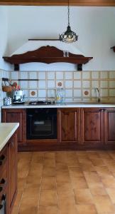 una cucina con armadi in legno e lavastoviglie nera di Villa Anna a San Venanzo