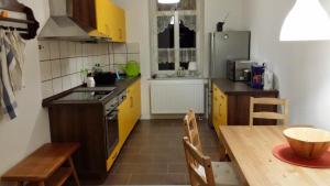 uma cozinha com armários amarelos e uma mesa de madeira com uma sala de jantar em Ferienwohnung Paschke Chemnitz Schönau em Chemnitz