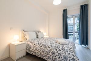 um quarto branco com uma cama e uma janela em Moreira Terrace no Porto