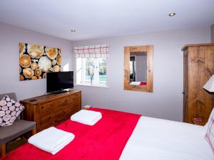 a bedroom with a bed with a red blanket at Pass the Keys Tranquil Hideaway in Wells, Somerset - One Bedroom Cottage in Wells