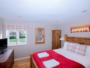 a bedroom with a bed with a red blanket at Pass the Keys Tranquil Hideaway in Wells, Somerset - One Bedroom Cottage in Wells