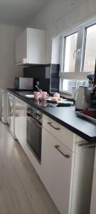 a kitchen with white cabinets and a black counter top at Ferienhaus Leoni in Rieden