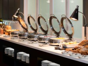 a buffet line with many pans and plates of food at Mercure Newcastle in Newcastle