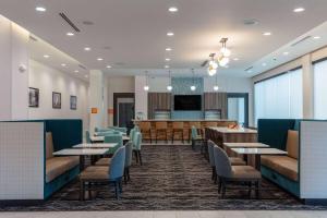 uma sala de jantar com mesas e cadeiras e um bar em La Quinta Inn & Suites by Wyndham Centralia em Centralia