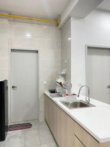a kitchen with a sink and a white door at Putrajaya AQ Homestay (Near PICC) in Putrajaya