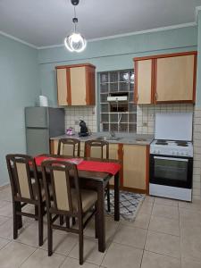 a kitchen with a table and chairs and a kitchen with a stove at VATA apartaments in Thessaloniki