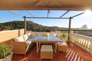 patio con sofá y mesa en el balcón en Ty Croeso-Entire villa with sea view, en Calpe