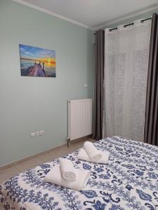 a bedroom with a bed with two towels on it at VATA apartaments in Thessaloniki